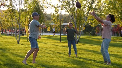 happy parents and child playing rugby outdoors. family fun with a ball in the sunlit park. - Powered by Adobe