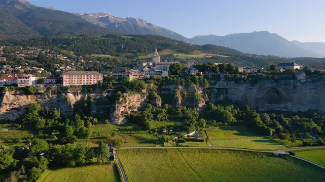 Aerial view of Embrun and its famous cliff-top plateau. Summer in Durance Valley in Hautes-Alpes. French Alps, France