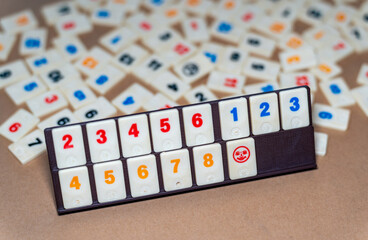 Classic board game of Rummikub, tiles with numbers in sequence, focus on joker tile