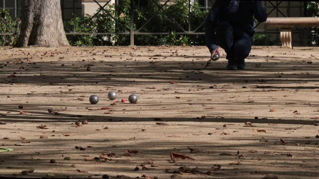 Man playing boules (petanque) game in a park