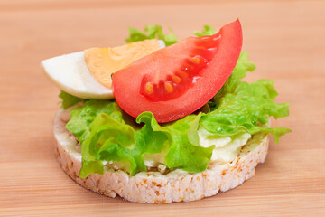 Rice Cake Sandwich with Tomato, Lettuce and Egg on Bamboo Cutting Board. Easy Breakfast. Diet Food. Quick and Healthy Sandwiches. Crispbread with Tasty Filling. Healthy Dietary Snack