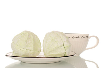 Sweet delicious pear marshmallow on ceramic saucer with cup, macro isolated on white background.
