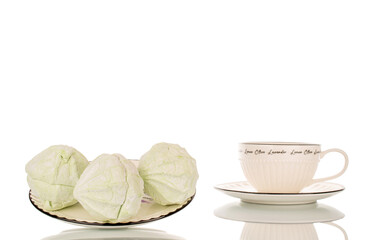 Sweet delicious pear marshmallow on ceramic saucer with cup, macro isolated on white background.