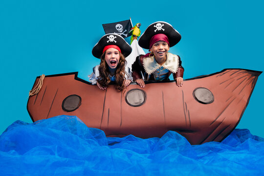 Photo of two funky small kids halloween pirate costume sail ship isolated on blue color background