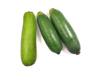 Top view of three fresh zucchinies, also known as courgette or baby marrow (Cucurbita pepo), isolated on a white background. 