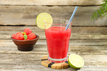 Tasty watermelon drink in glass and fresh fruits on wooden table