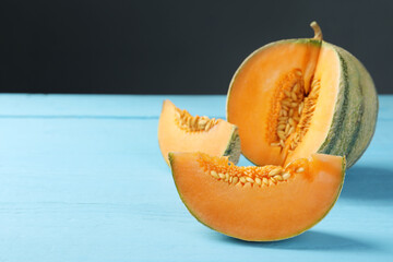 Cut ripe Cantaloupe melon on light blue wooden table, closeup. Space for text