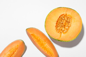 Pieces of fresh Cantaloupe melon on white table, flat lay. Space for text