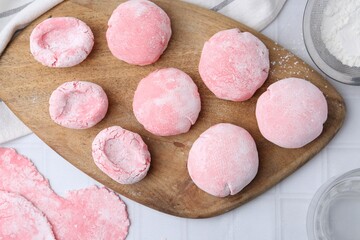 Tasty homemade mochi on white tiled table, top view