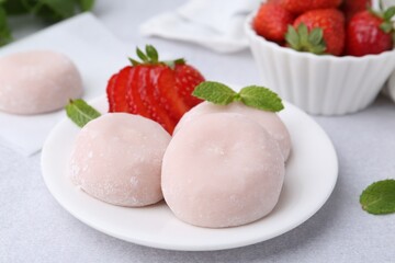 Delicious mochi, strawberries and mint on light grey table, closeup