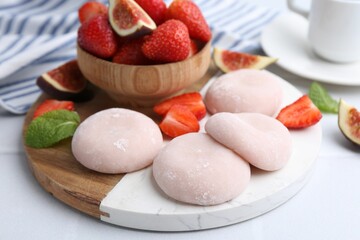 Delicious mochi, strawberries and fig on white table, closeup