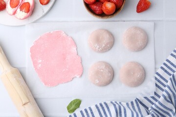 Tasty homemade mochi, dough and strawberries on white table, top view