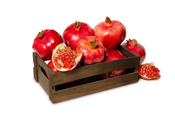 wooden crate with fresh pomegranates isolated