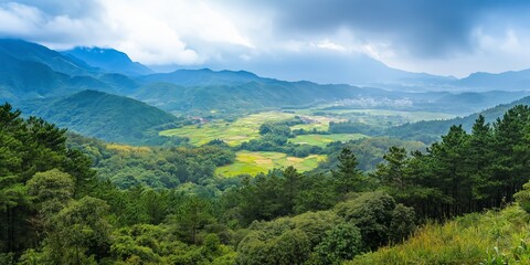 A lush green valley with a mountain in the background. The sky is cloudy and the sun is shining through the clouds