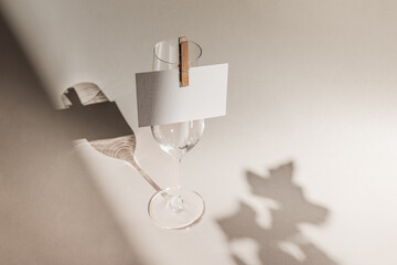 Modern blank name card template mockup attached on champagne glass with copy space