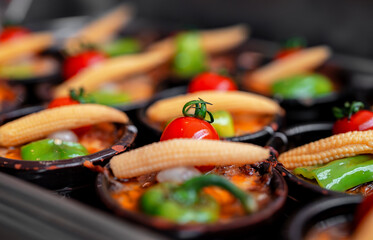 Baked potato gratin topped with tomato, paprika and corn.