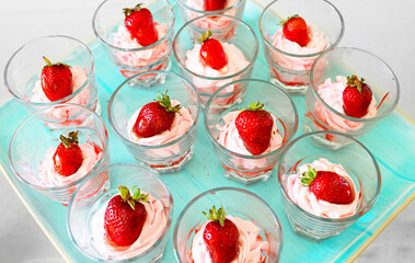 Glasses of whipped cream with strawberries.