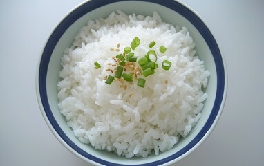 Soft, fluffy Thai jasmine rice served in a simple, elegant bowl with a sprinkle of sesame seeds and sliced green onions on top