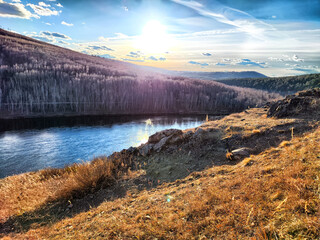 Sunset over the river with hills in autumn