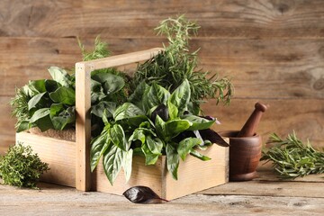 Different fresh herbs in basket on wooden table