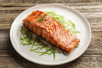 Delicious grilled salmon fillet served on wooden table, closeup