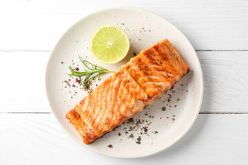 Delicious grilled salmon fillet served on white wooden table, top view