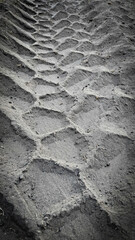 Tread pattern of big construction truck tires in soft loose sandy soil