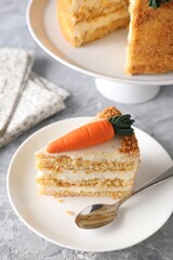 Plate with piece of delicious carrot cake on grey textured table