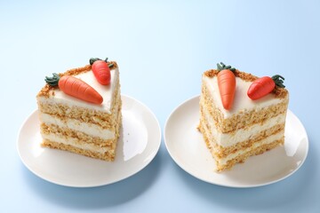 Pieces of delicious carrot cake on light blue background, closeup