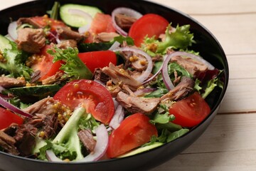 Delicious fresh tuna salad on wooden table, closeup