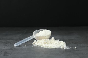 Protein powder and scoop on grey textured table