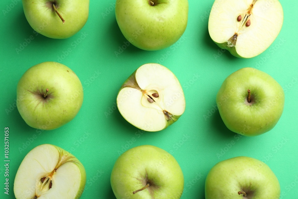 Poster Flat lay composition with whole and cut apples on green background