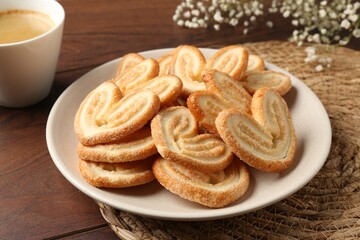 Delicious palmier cookies with coffee on wooden table