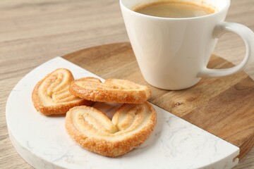 Delicious palmier cookies with coffee on wooden table