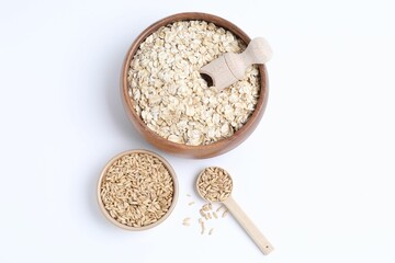 Oat flakes in bowl, grains, scoop and spoon isolated on white, top view