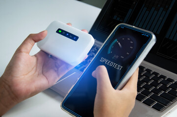 fast internet connection speedtest network bandwidth technology Man using high speed internet with smartphone and laptop computer. 5G quality, speed optimization