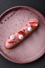 Sweet eclair or profiterole with strawberry custard