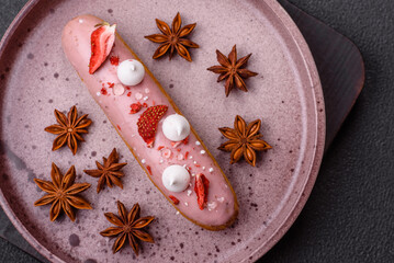 Sweet eclair or profiterole with strawberry custard