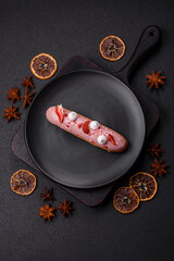 Sweet eclair or profiterole with strawberry custard