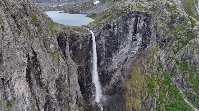The drone zooms in and rises slowly behind mountains and Mardalsfossen in Eikesdal comes into view. The waterfall is one of the tallest waterfalls in Europe. A whopping 705 meters of waterfalls. 4K.