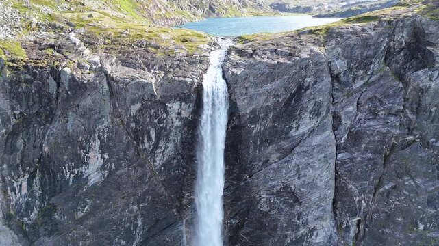 The drone zooms in and rises slowly behind mountains and Mardalsfossen in Eikesdal comes into view. The waterfall is one of the tallest waterfalls in Europe. A whopping 705 meters of waterfalls. 4K.