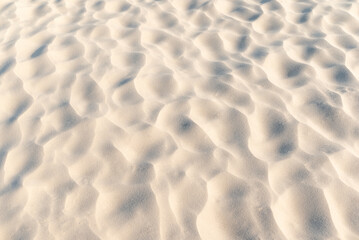 Close up of sand on beach. Clean sand with waves made by wind, beautiful nature texture