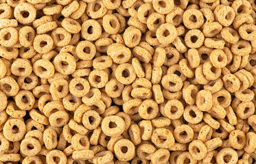 Sweet breakfast cereal rings as background, top view. Healthy breakfast. Cereal background. Whole grain oat cereals.