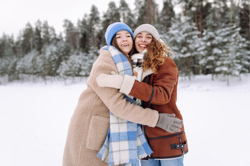 Fototapeta premium Happy friends having fun playing in winter park. Friends communicate and enjoying nature.