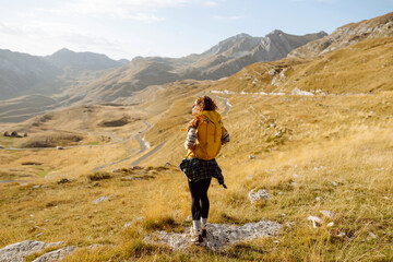 Fototapeta premium Young woman backpacker on mountains cliff hiking enjoy landscape. Adventure active. Mountain climbing.