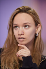 Closeup of a young woman's visage with piercing hanging from her nose.