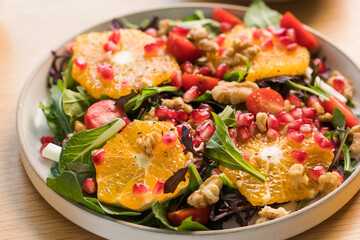 Vegan salad with citrus fruits, lettuce leaves and pomegranate. Christmas salad. 