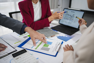 Team of business professionals is working together, analyzing financial data and using a digital tablet to discuss investment strategies
