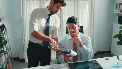 Obraz premium Top view of skilled businessman walking and give house design. Aerial view of architect engineer looking at blueprint and building structure at table with safety helmet and house model. Alimentation.