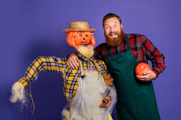 Photo of man gardener creepy scarecrow doll guarding field halloween carnival autumn season isolated on purple color background